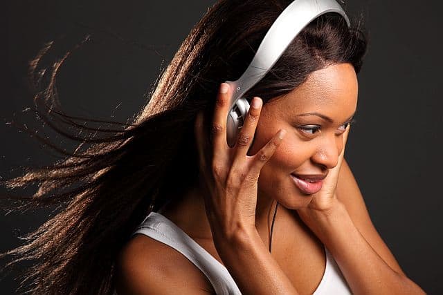 African-American girl with chemically straightened hair listening to music