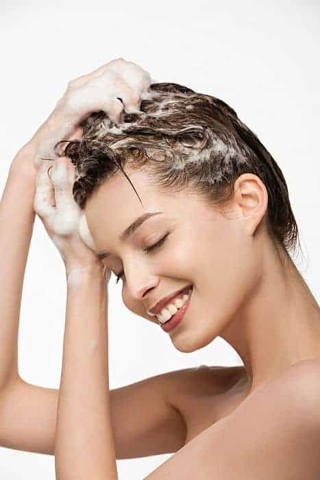 Smiling girl using a mild clarifying shampoo