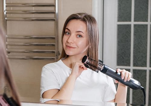A girl using hair dryer brush