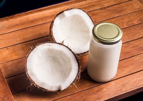A cracked coconut and jar of coconut oil