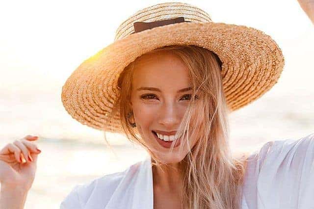 A cute girl with beachy hair wearing a hat
