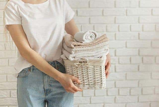 A woman holding a basket of microfiber towels