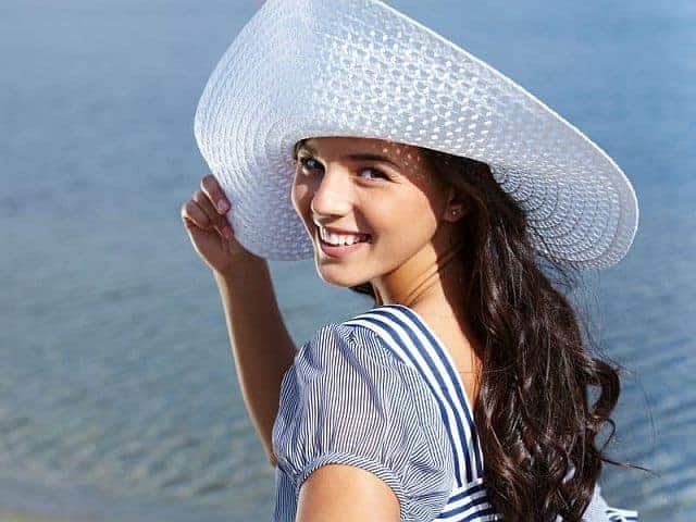 A woman wearing a hat to protect the hair from the Sun