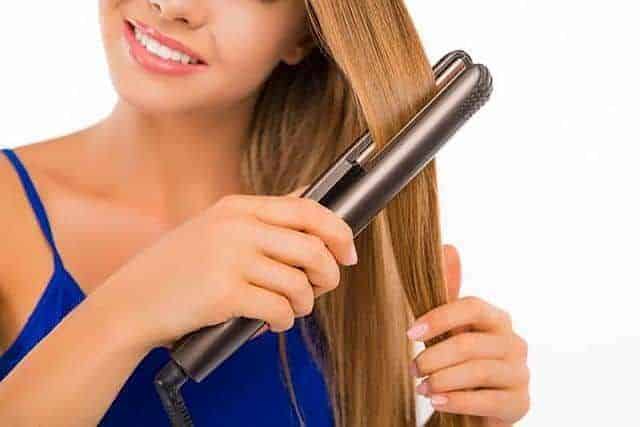 Girl using a Flat Iron to style her hair