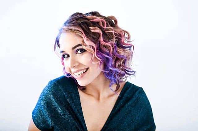 Smiling girl with wax colored rainbow hair