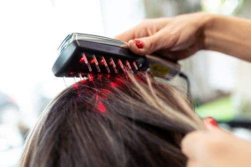A woman using laser comb