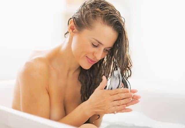 Woman applying deep conditioner in the shower