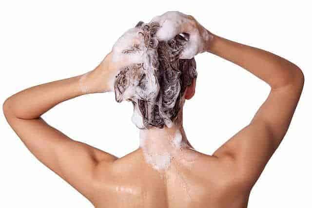 Woman washing her colored hair with dandruff shampoo