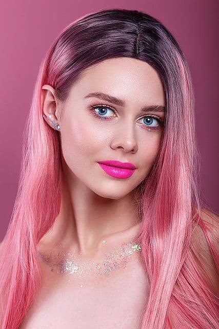 Woman with blue eyes wearing pink synthetic vig
