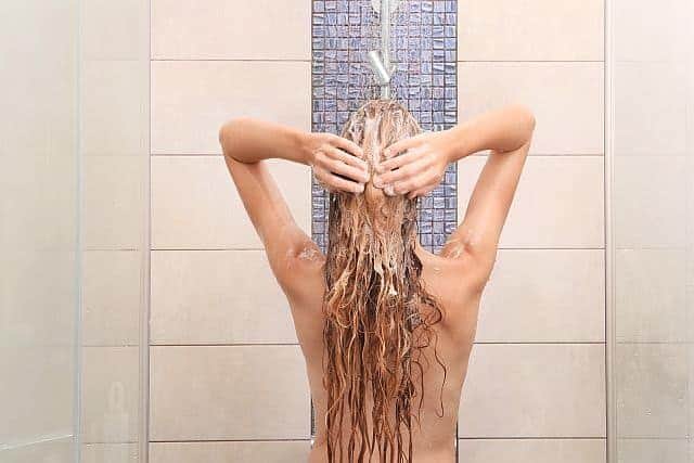 Woman with hair extensions taking a shower
