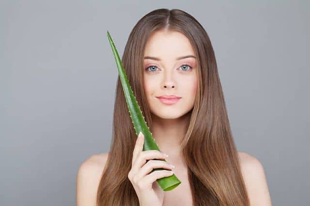 a girl with healthy hai -holding aloe vera leaf