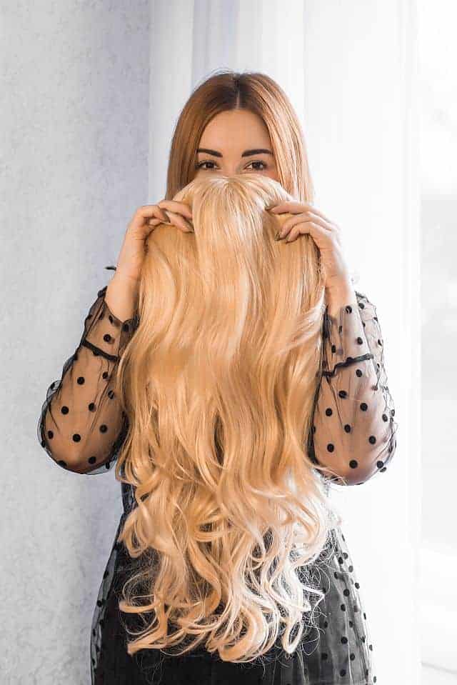 a woman displaying her long synthetic wig