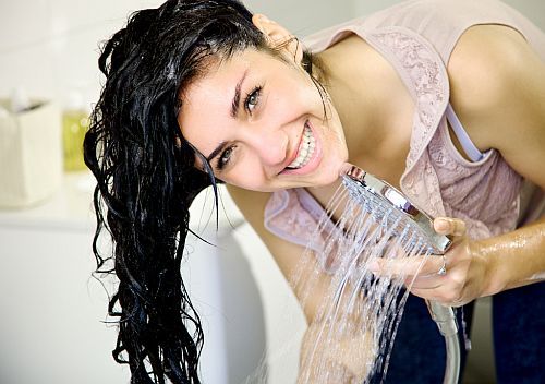 a woman washing the hair with repairing shampoo