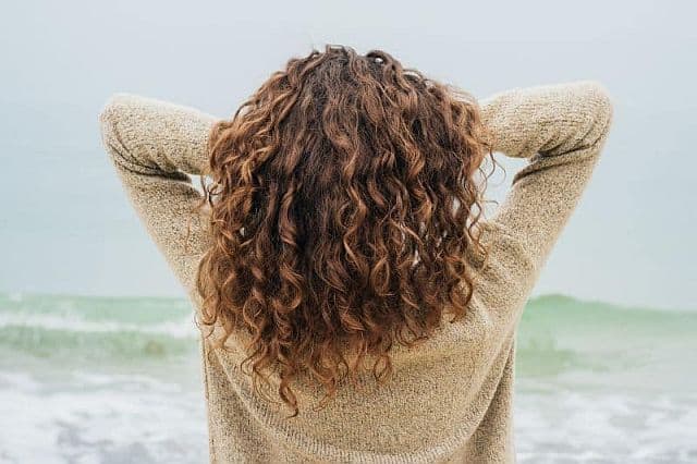 a woman with wavy hair on the coast