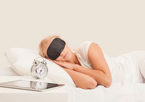 woman in bed wearing a sleeping mask