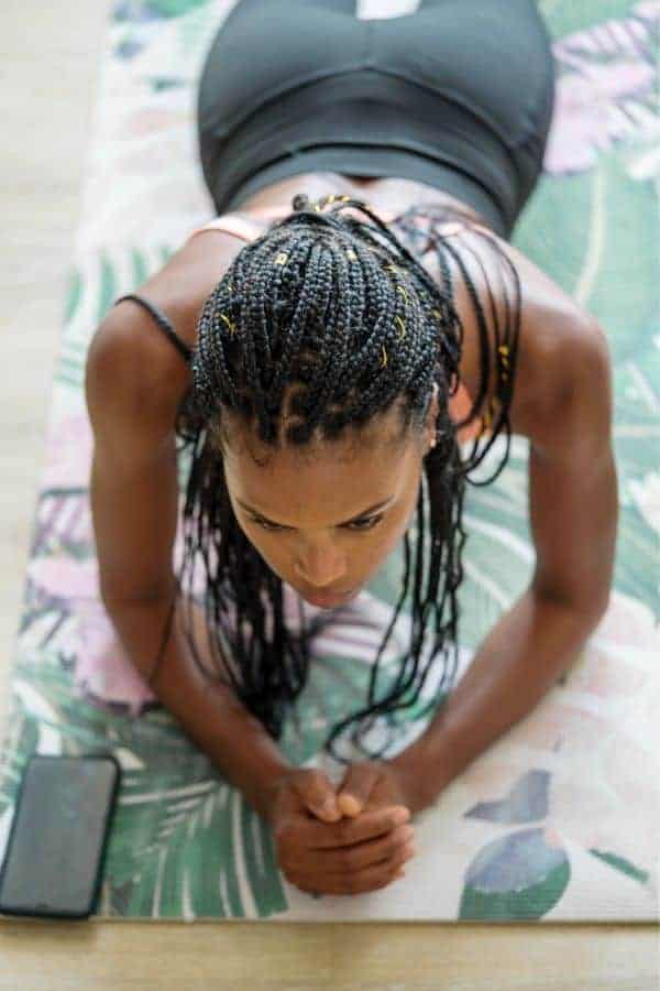 a dark-skinned girl with brided hair during workout