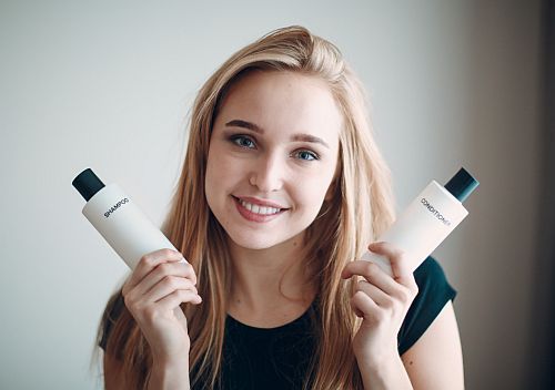 girl holding two shampoo bottles