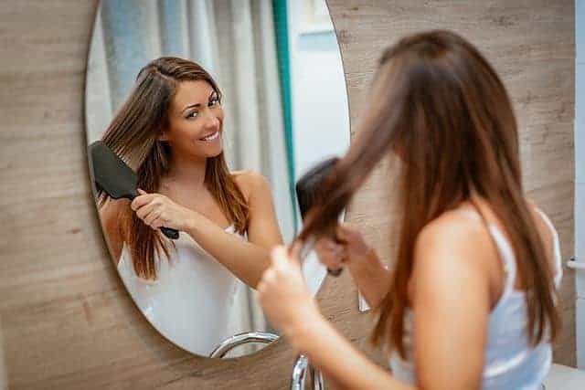 The woman uses an ionic brush to brush her hair