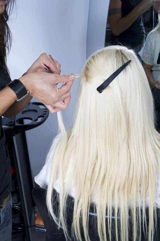 hair stylist installing hair extensions