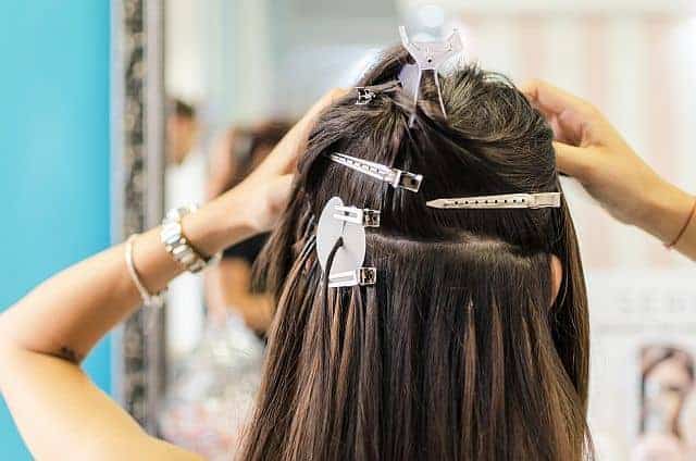 checking the condition of hair extensions in the salon