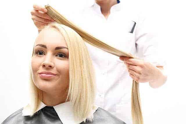 stylist attaching hair extensions