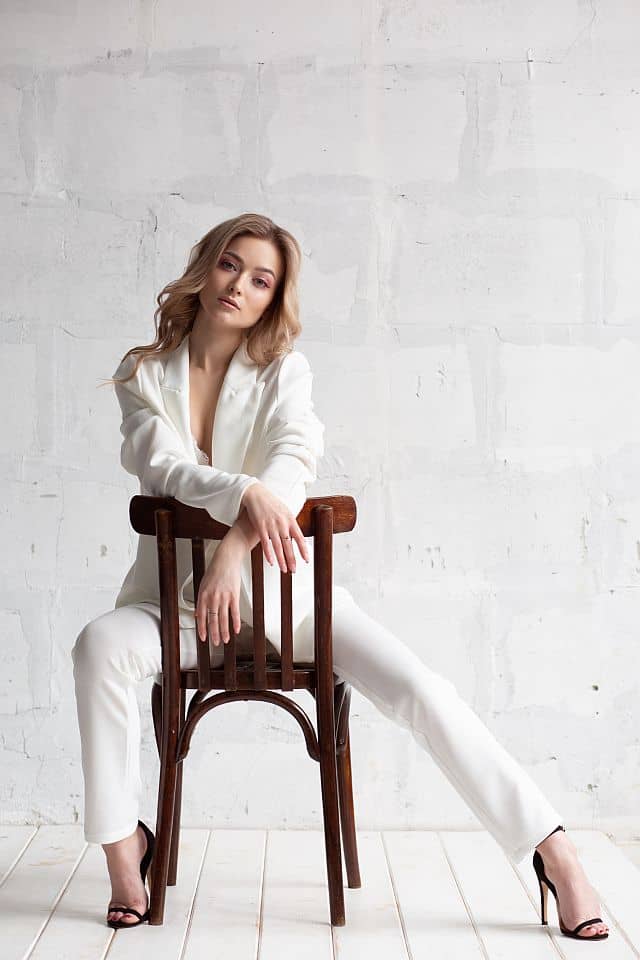 A woman with frizz-free hair and perfect blowout  wearing elegant white suits