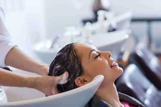 Hairdresser washes client's hair with sulfate-free clarifying shampoos