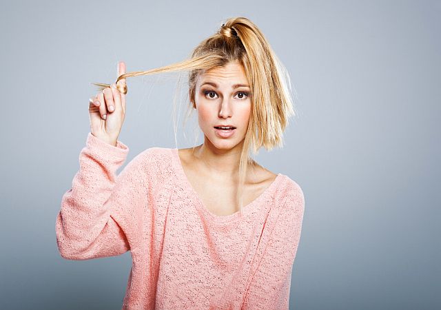 a blonde girl experiencing hair breakage