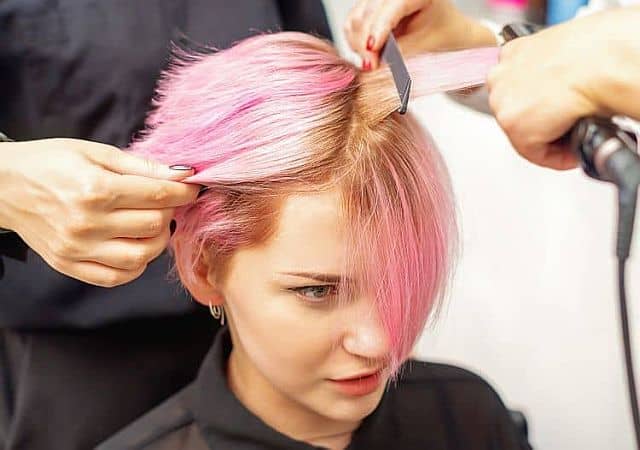 a hair stylist uses flat iron for short hair