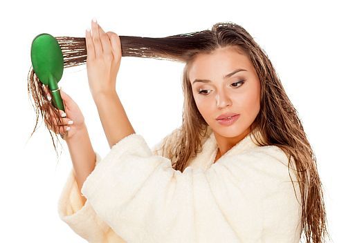 a woman detangling her hair after applying a leave-in conditioner