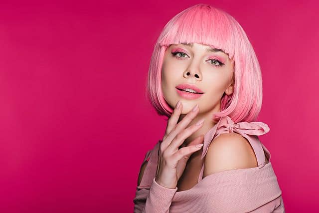 girl with a pink synthetic wig posing in the studio