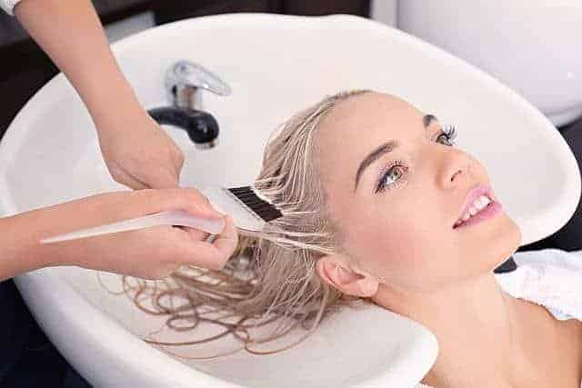 hairdresser performing salon hair repair treatment