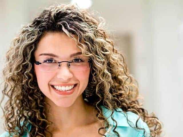 smiling girl with permed hair wearing a glasses