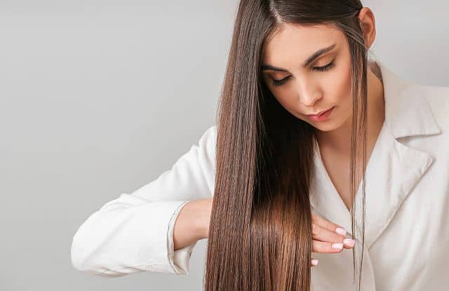 A woman touching her perfectly straight hair