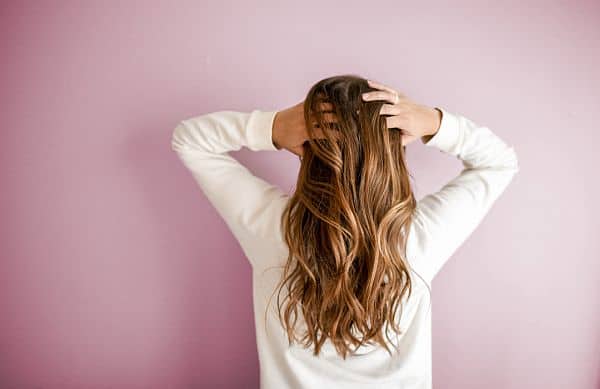 a woman touching her long oily hair