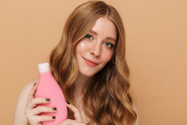 a beautiful woman holding a shampoo bottle