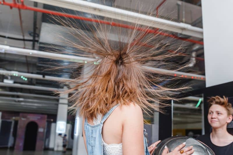  woman with standing hair from static electricity at physics museum