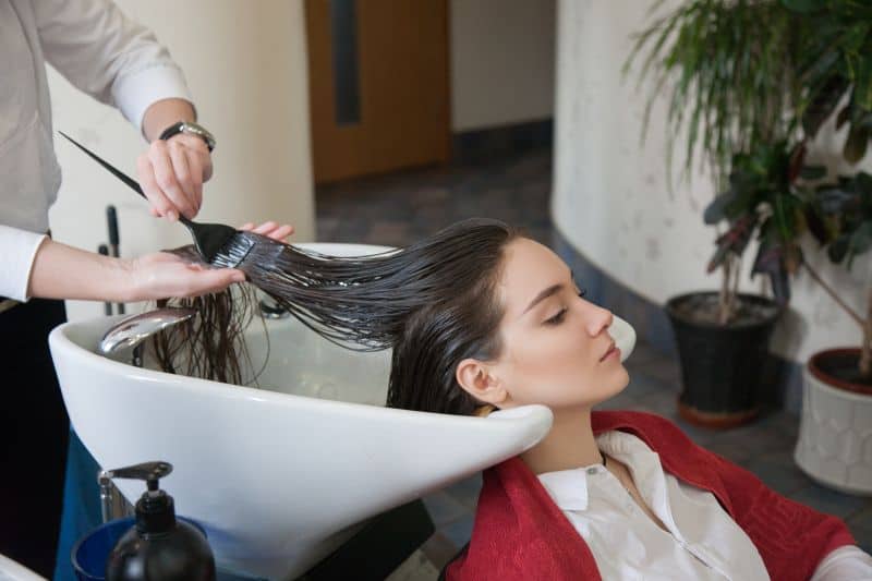 Hairdresser correcting dark hair color