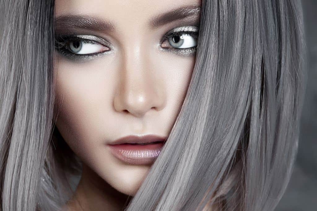 Young beautiful model with silver make-up and dark silver hair