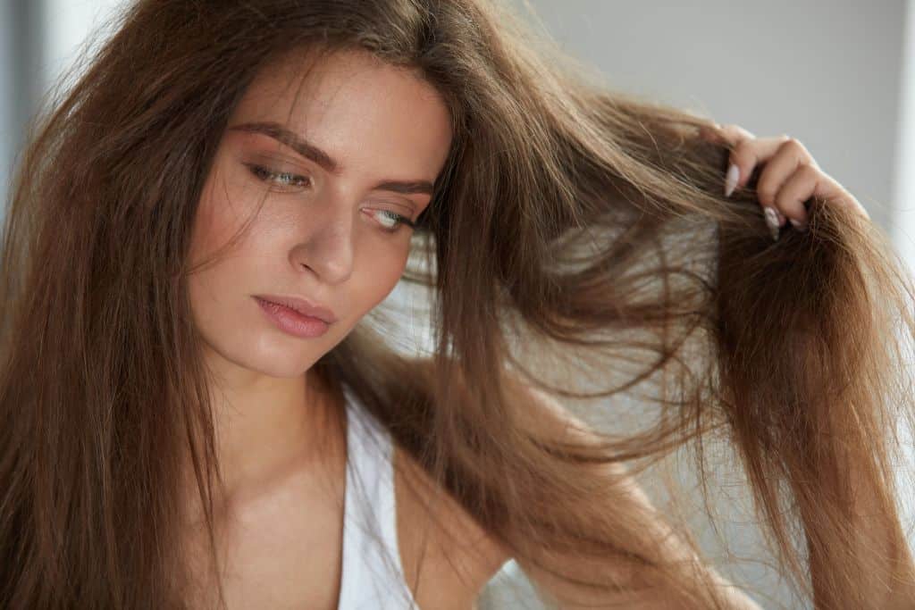 a young woman feels bad about her damaged hair