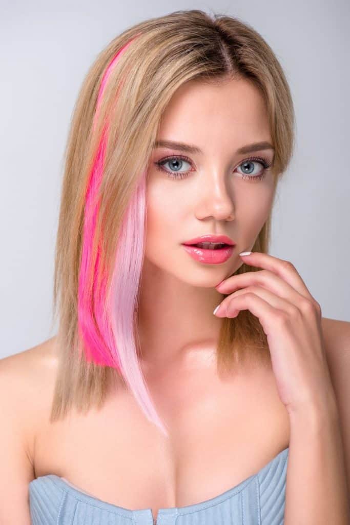 beautiful young woman with colored hair strands in her hair