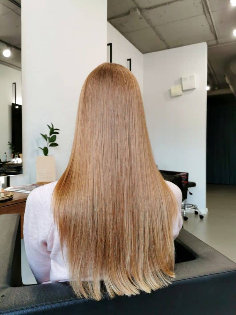 Beautiful girl with straightened hair in a beauty salon