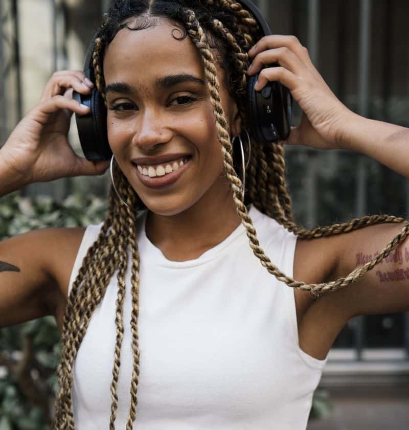 Girl with long blonde braids and edges listening to music