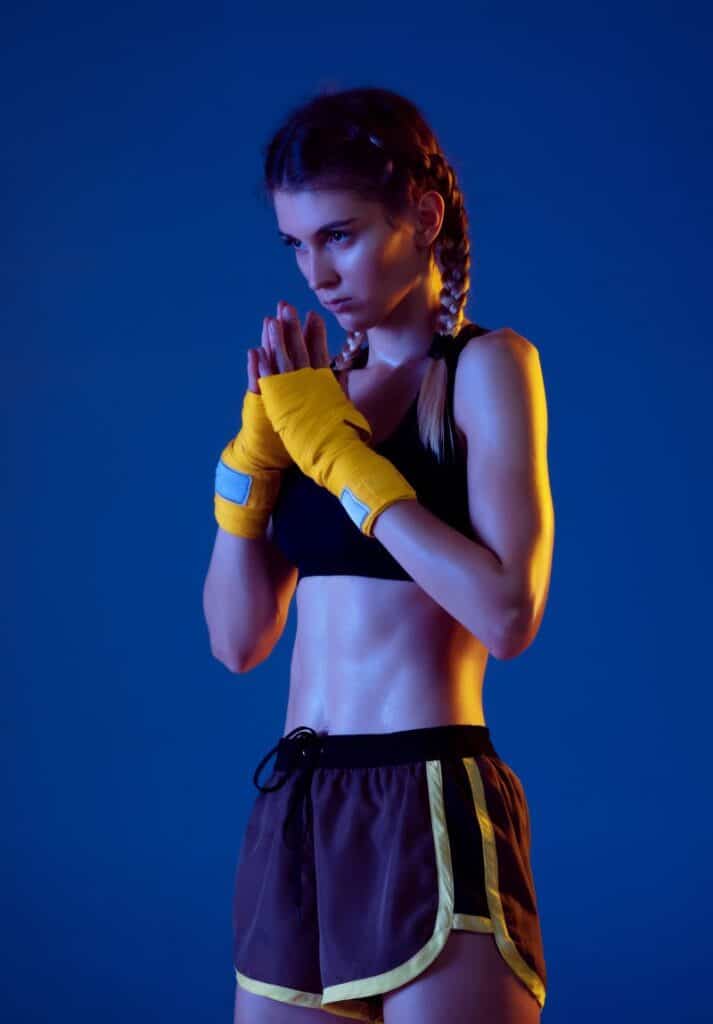 Cute young woman boxing and wearing braids