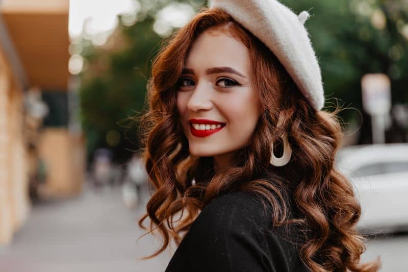 smiling women with ginger colored hair and red lips