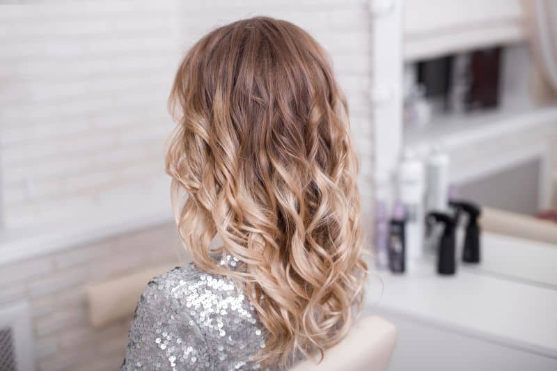 a woman with blonde curly ombre hair