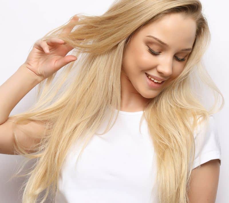 happy smiling blond girl touches her hair 