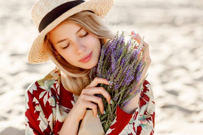 lovely romantic blond girl enjoying the perfect smell of lavender