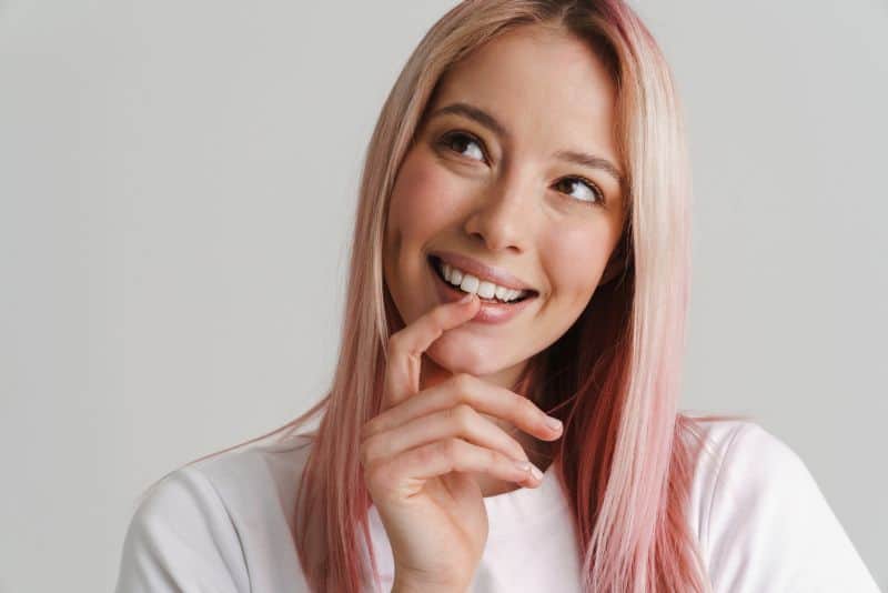 Young woman with pink hair smiling 