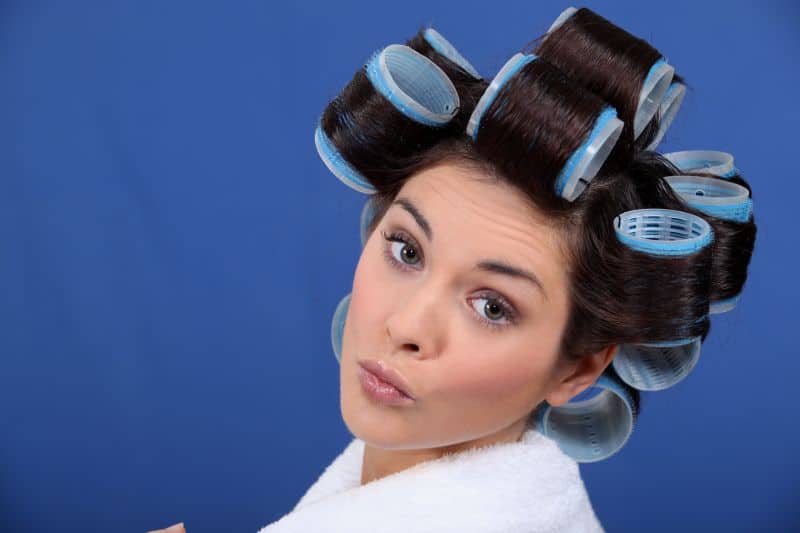 brunette woman in welcro rollers looking at camera